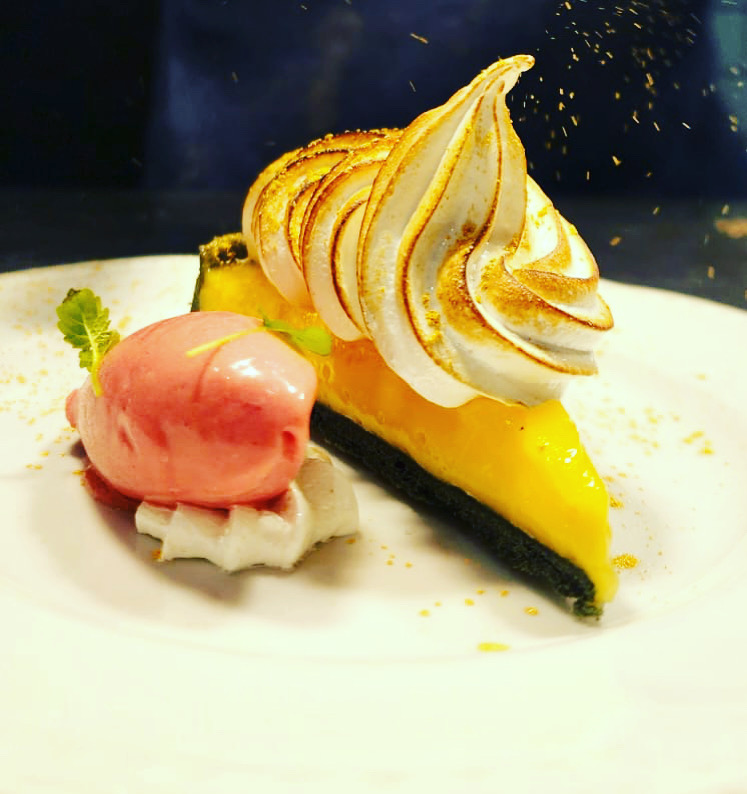 Plated citrus tart and meringue dessert