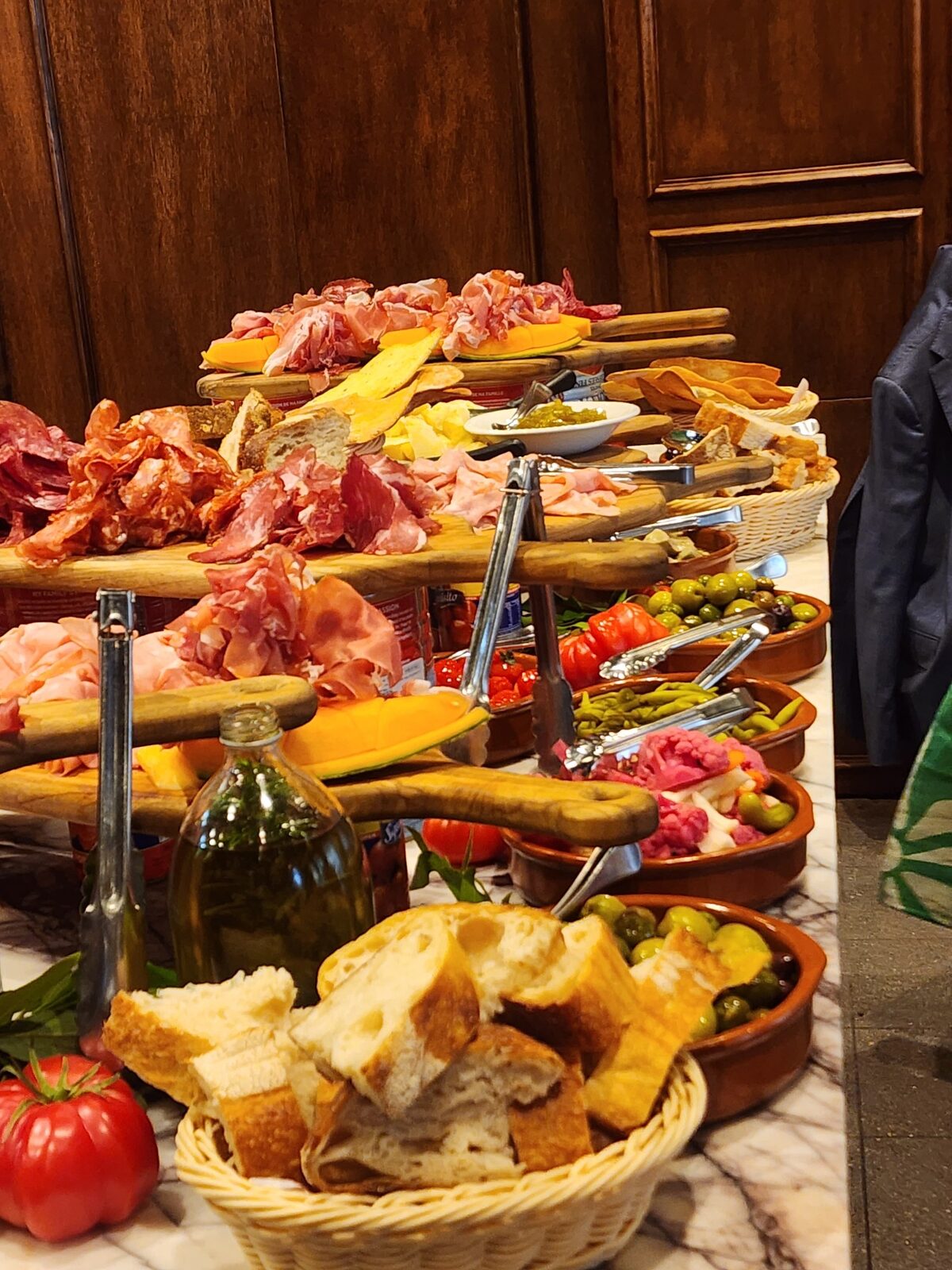 A generous Italian grazing table with cured meats, cheese, olives and bread