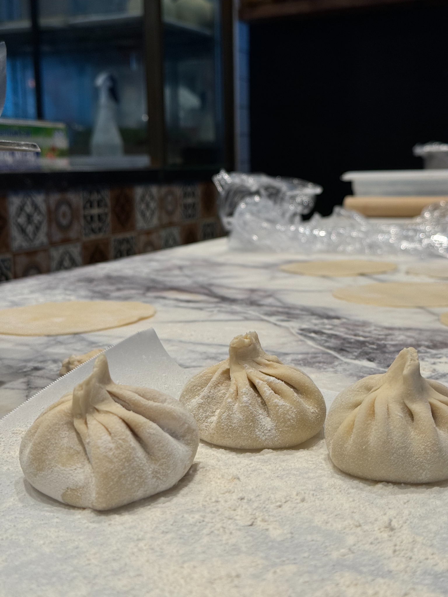 Freshly folded khinkali resting on a floured bench